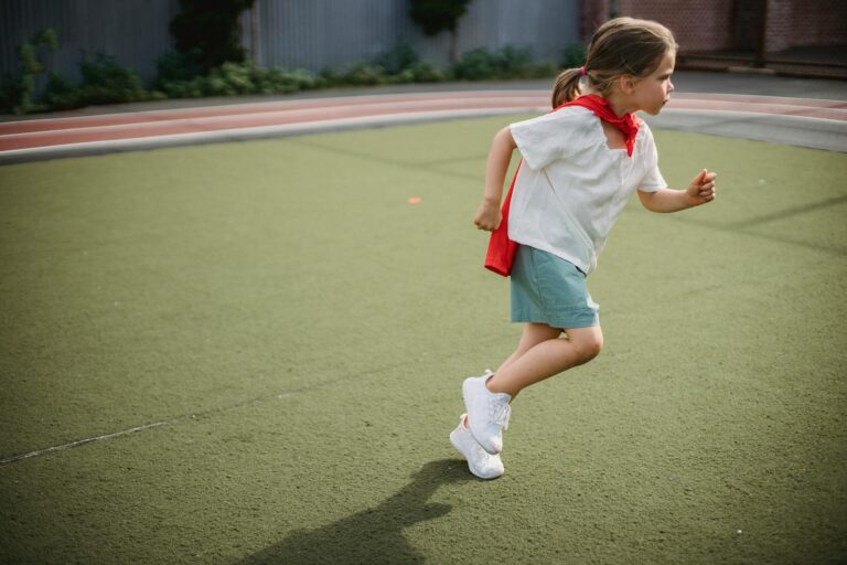 little girl wearing a superhero cape running